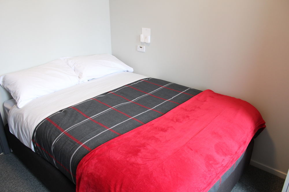 Ostello Urbanz Christchurch Esterno foto A bed with a throw